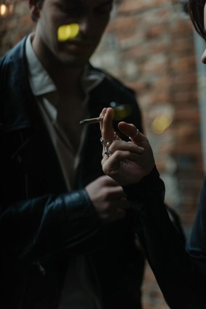 two people smoking a marijuana joint