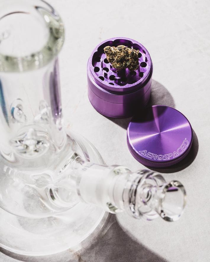 Weed grinder next to a bong